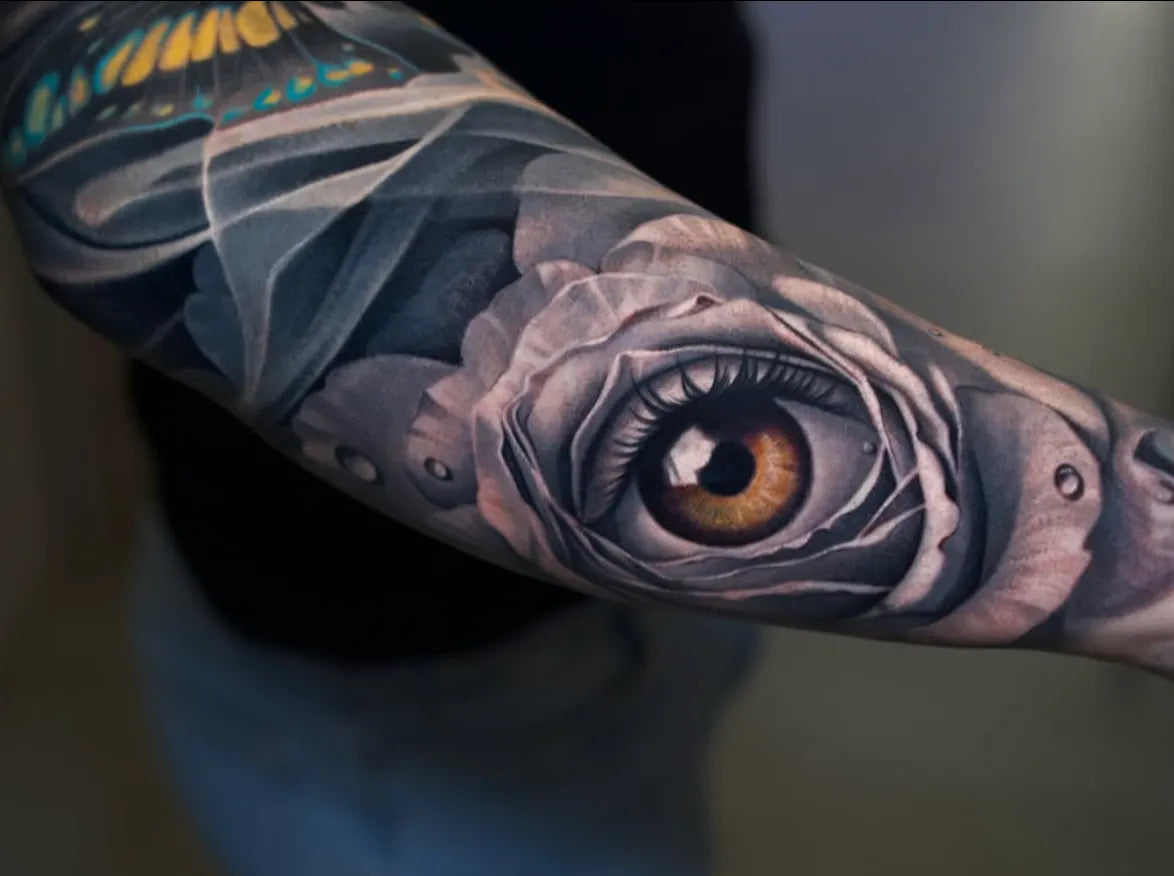 Realistic eye and rose tattoo on a forearm by Adrian Rod